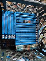 Hardy Boys books numbered 1 to 22 with blue hardcover spines in a crate, including volumes like 4, 7, 10, 12, 13, 19, 20, 21, 22.