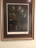 Full view of the framed lithograph hanging on a wall, showing the artwork and the frame.