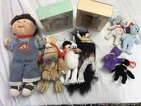 Photo showing the entire lot including Cabbage Patch boy doll, 3 Where the Wild Things Are plush figures, 5 Ty Beanie Babies miniatures, and 2 unopened Littlest Bears boxed figurines