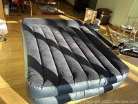 Air mattress inflated and viewed from above showing vertical air chambers and dark color.