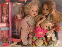 Bin containing 2 Barbie dolls in original boxes and other loose dolls with accessories