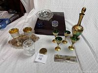 Full lot showing emerald glass decanter set, silver tray with goblets, brass calendar, and lap desk.