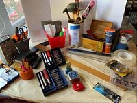 Overview of artist tools including knives, screwdrivers, rulers, tapes, sanding blocks, and picture hangers