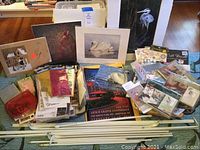 Lot overview showing multiple art prints, stickers, curtain rods and storage containers.