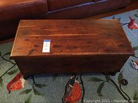 Front angle view of the wooden cedar chest showing the closed top and wood grain.