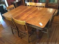 Overall view of oak rectangular dining table with two drop leaves and six matching chairs