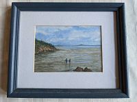 Framed watercolor painting of seashore landscape with two figures walking in surf near rocks and trees.