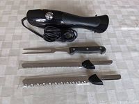 Electric cutter set components: black electric handle, two serrated blades, and one fork.
