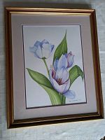 Framed watercolor painting showing three flowers with green leaves in a gold-tone frame with a double mat.