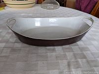 Side view showing the dark brown exterior and shape of the pan with handles.