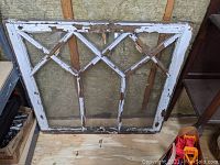 Full view of the vintage wooden window pane showing the full geometric pattern and paint chipping.