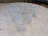 Front and top view of the set of six Westmoreland Glass sherbet glasses arranged in a semicircle on a table.