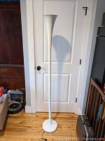 Full view of floor lamp showing base, column and up-light