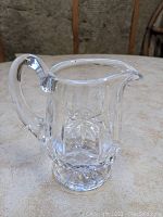 Side view showing the handle and spout of the Waterford Lismore crystal creamer.