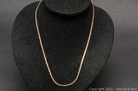 Full view of gold chain displayed on black bust