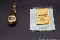 Pulsar watch next to instruction manuals on dark background