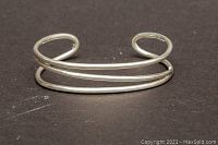 Front angle view of the double band sterling silver bangle on dark background showing overall shape and design.