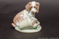 Front view of Lladro dog figurine with flower pot and pink flowers