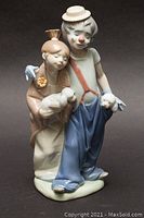 Front view of Lladró porcelain figurine showing two children holding small dogs.