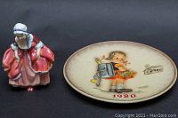 Both Royal Doulton figurine and Goebel plate together for size comparison and overall view