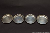 Four round sterling silver bowls arranged side by side from top view showing the interior of each bowl.
