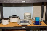 Wide view of all dinnerware including Royal Doulton Babylon plates, Wedgwood Mosaic bowls and plates, Rosenthal cup and saucer, and casserole dishes.