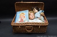 Wicker basket loaded with the Shirley Temple Book of Fairy Tales and three vintage dolls.