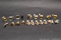 Photo showing 17 figurines including duck, camel, elephant, multiple cats, rabbits, turtles, and horses on a black background