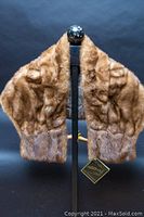 Front view of brown vintage mink fur stole displayed on a mannequin stand, showing natural fur texture and size.