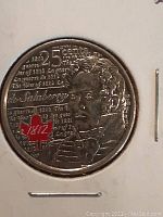 Close-up of the obverse side of the 2013 Canadian 25-cent coin featuring Charles-Michel de Salaberry with coloured accents including a red maple leaf marked '1812'.