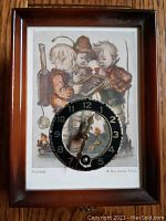 Front view of the miniature key wind clock with Hummel image showing three children and the black clock face with hands and keyhole.