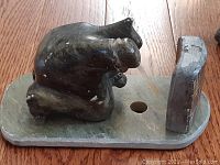 Side view of hand-carved soapstone bear sculpture on rectangular base.