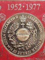 Close-up of the backside of the Silver Jubilee coin showing crowned emblem and floral wreath with inscription.