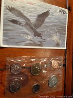 Photo of unopened package containing 6 Canadian coins beside packaging showing loon illustration and year 1992