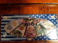 Top view of the oval-shaped coin holder containing commemorative American quarters from the Millennium series and 2001 state quarters.