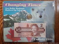 Front view of the display showing Canadian two dollar bill and coin embedded with scenic background and polar bear image