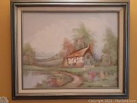 Front view of the oil on canvas painting "Our Tudor Cottage" featuring a Tudor-style cottage, pond, trees, and pathway, housed in an original wooden frame.