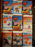 Nine unopened vintage hockey card packs featuring Score 1991 Series 1 and Series 2, Score 1990, and Topps 1991, laid on table showing front colorful designs with various players.