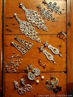 Overview of all jewelry items including earrings and one ring arranged on wooden surface.