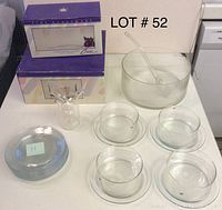 Display of glass bowls, plates, punch bowl with ladle, with some items still boxed