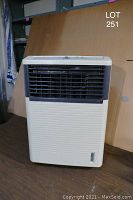 Front view of beige electric evaporative cooler/humidifier unit with air vents and control knob.