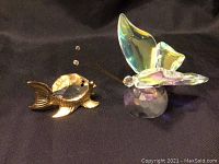 Photo showing both the gold plated fish figurine with faceted crystal body and the crystal butterfly figurine with iridescent wings and faceted base.