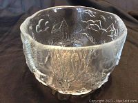 Front angle showing the clear glass bowl with detailed embossed town hall and nature scene artwork with textured surface.