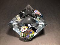 Top angled view showing the clear octagonal crystal shape and colorful Millefiori glass orb and decorations on top.