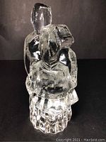 Front clear view of the crystal sculpture showing two abstract Nordic folk figures with an intertwined posture.