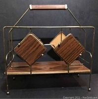 Front view of the brass and MDF wood magazine rack with diamond wooden panels and wood handle.