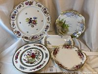 Overview of 5 assorted vintage china plates and platters arranged together showing patterns and shapes