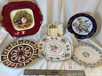 Photo showing all six china serving dishes and plates arranged on a white draped cloth, highlighting size and overall look.