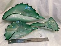 Set of three green chalet-style saw tooth edge art glass bowls with measuring ruler for scale, showing sizes ranging from about 9 to 15 inches