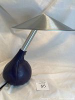 Side view showing the purple leather teardrop sandbag base and angled metal shade